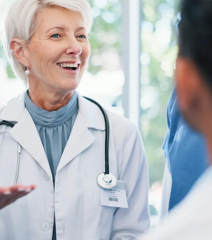 Erfahrene Hausärztin im Austausch mit Kolleg:innen während eines Mentorings