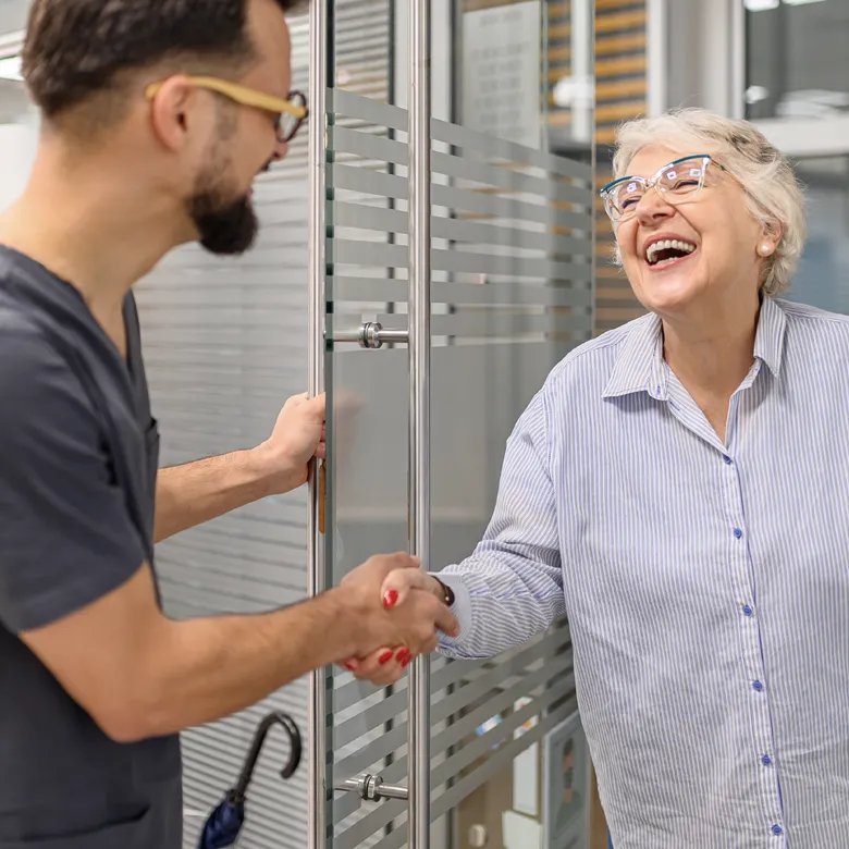 Herzliche Begrüßung zwischen einem Hausarzt und einer Patientin als Zeichen für persönliche Versorgung im ländlichen Raum